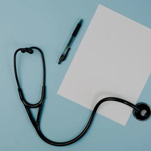 Stethoscope and blank paper on a blue background