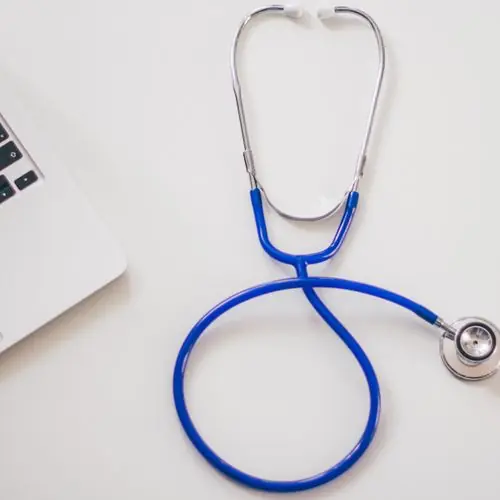 Blue stethoscope on a white desk