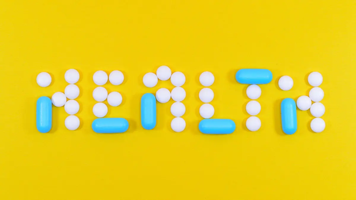 The word HEALTH spelled out in pills on a yellow background