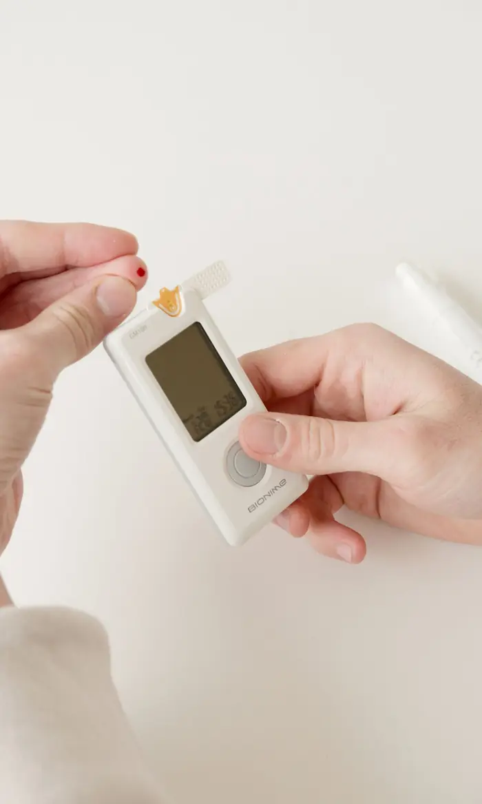 Close-up of hands using a glucose meter