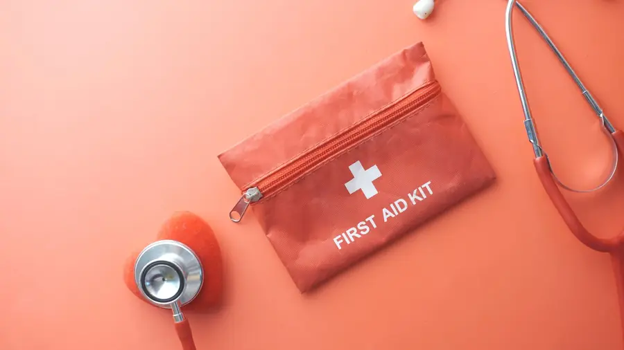 Red first-aid kit next to a stethoscope